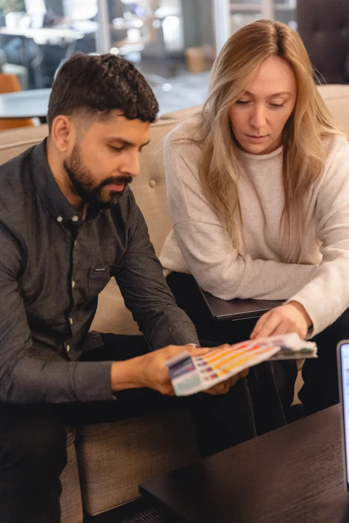 Two A&H designers looking at a Pantone color book