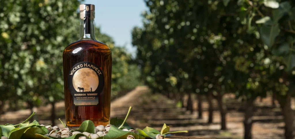 Wicked Harvest Spirits bottle of bourbon in a field of pistachios